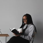 woman in white and black stripe long sleeve shirt sitting on chair