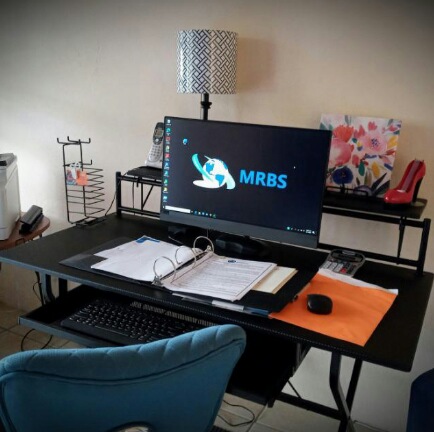 A home office setup with a computer monitor, keyboard, mouse, desk organizer, lamp, and some decorative items on a desk.